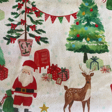 Christmas-themed fabric with Santa Claus, reindeer, trees, and presents on a beige background.