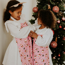 Two children in front of a decorated Christmas tree.